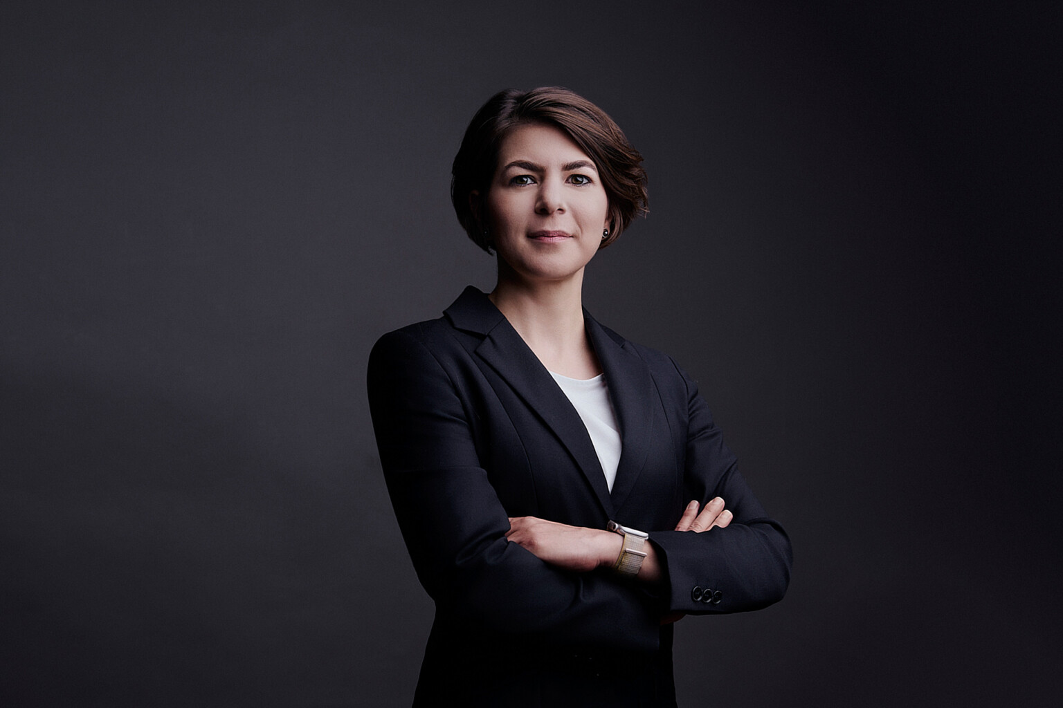Woman with short hair in a black blazer with folded arms, business portrait Frankfurt