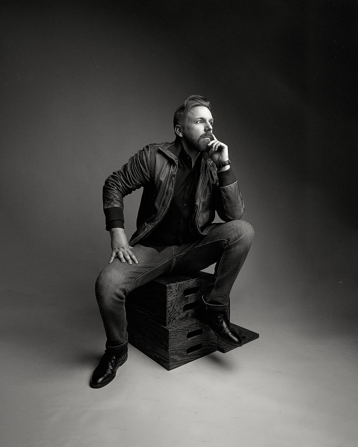 Mann mit Bart in Lederjacke und Jeans auf einer Holzkiste, Casual Portrait Fotostudio Frankfurt
