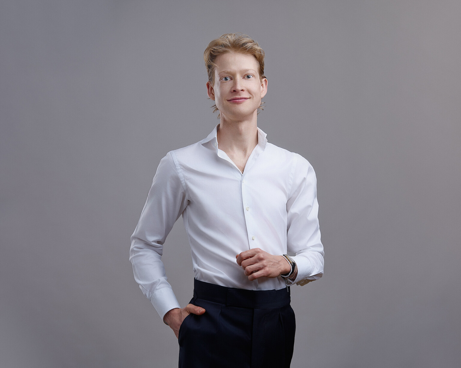 Job application photo of a young man in a white shirt against a grey background, Frankfurt