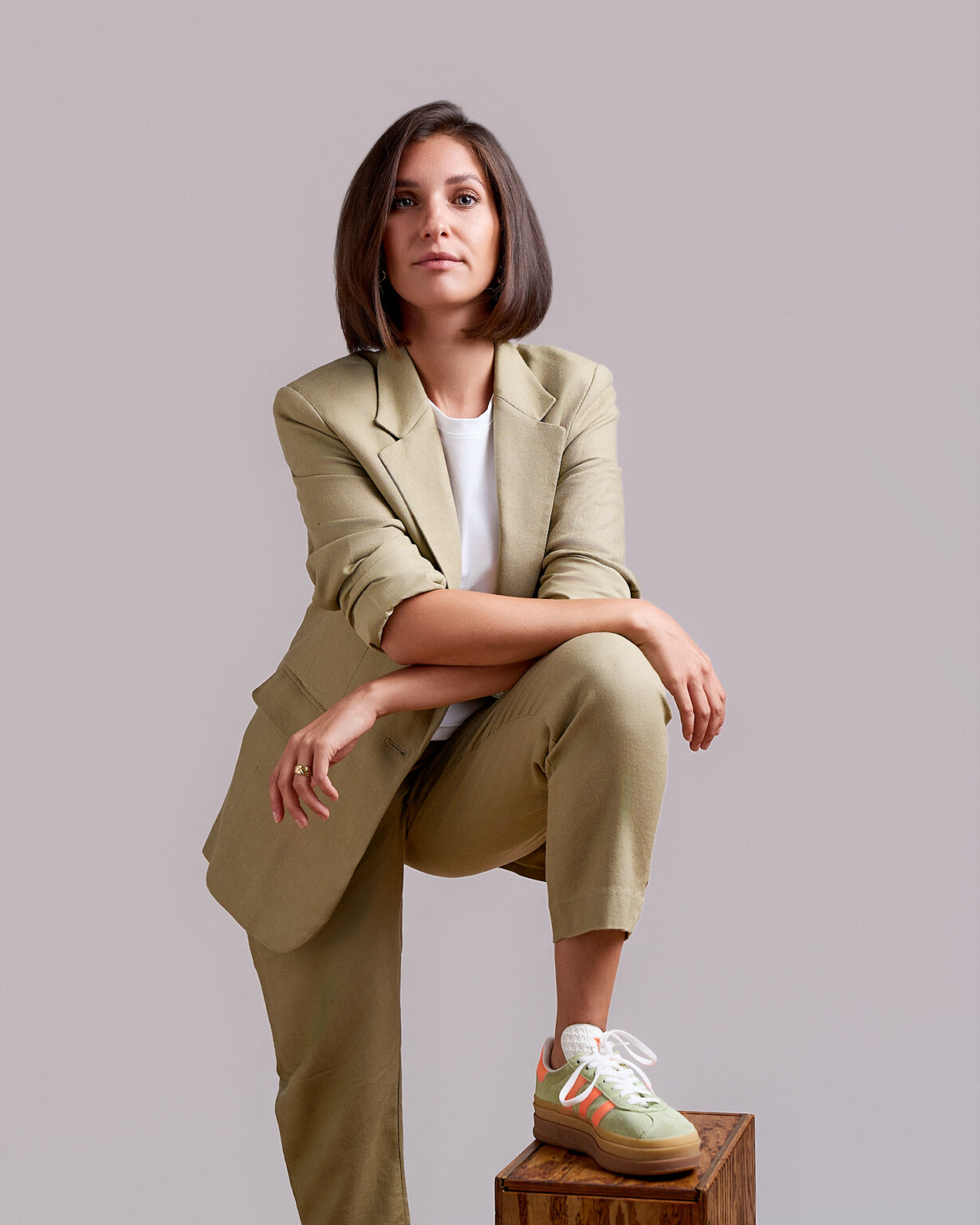 Frau im hellbraunen Anzug mit Fuß auf einem Holzblock, Business Portrait Frau Fotostudio Frankfurt