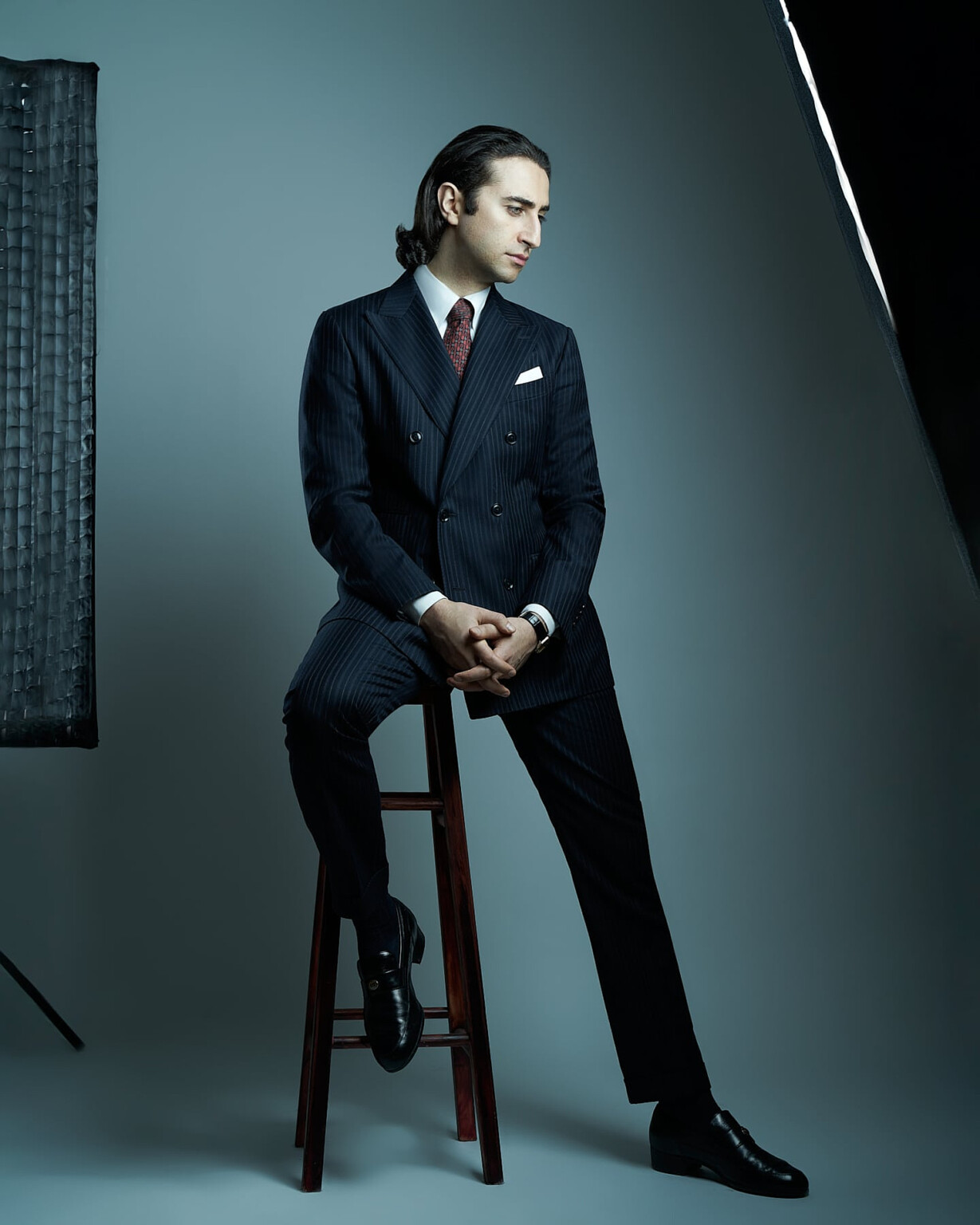 Mann im Nadelstreifenanzug auf einem Hocker im Studiolicht, Business Portrait Frankfurt