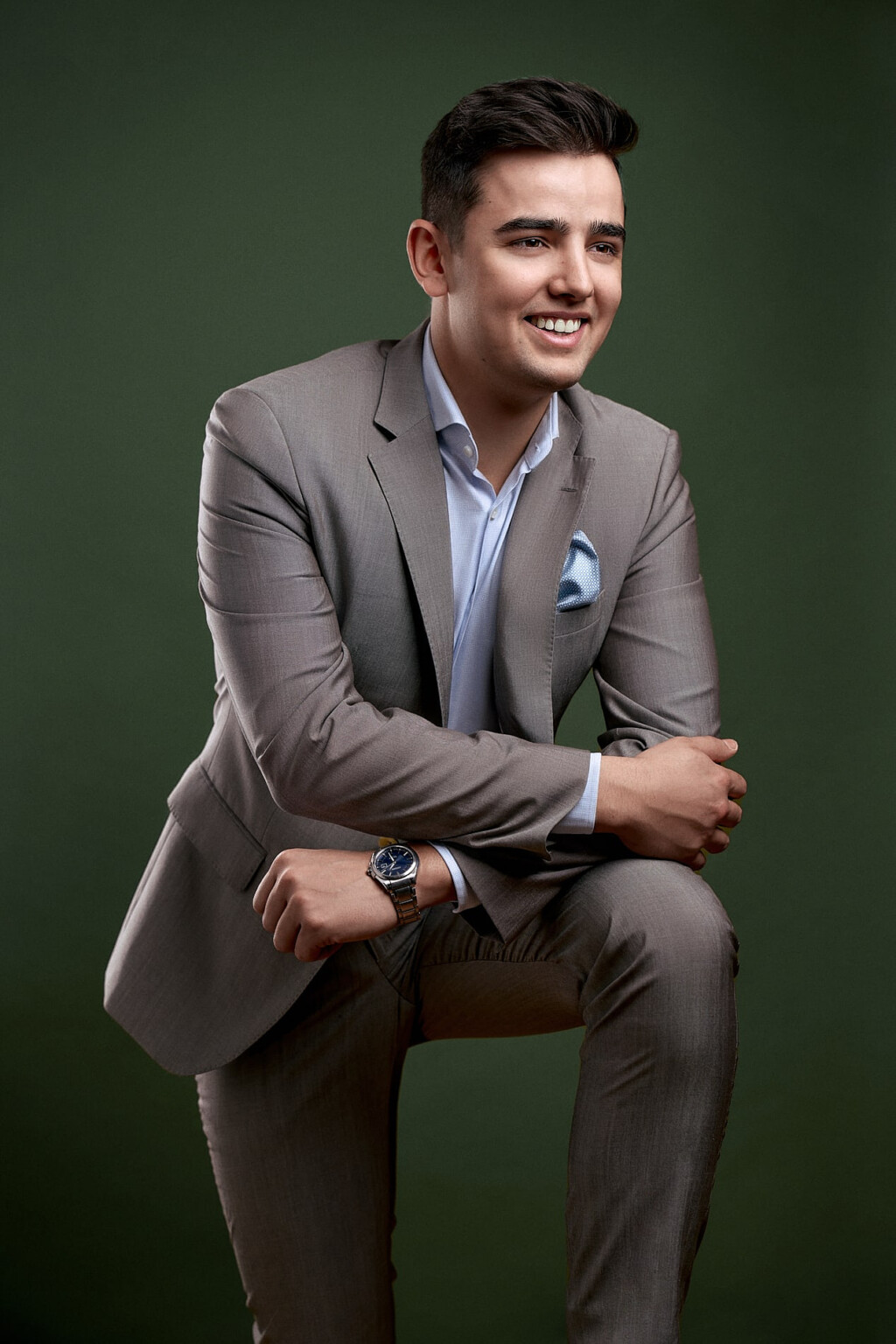 Lächelnder Mann in hellgrauem Anzug vor dunkelgrünem Hintergrund, Business Portrait Frankfurt