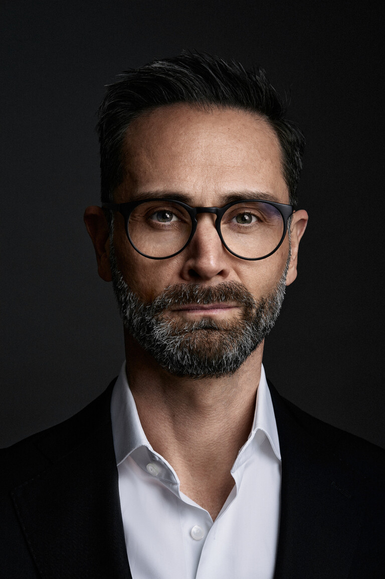 Nahes Business Portrait eines Mannes mit Brille und Bart, direkter Blick in die Kamera