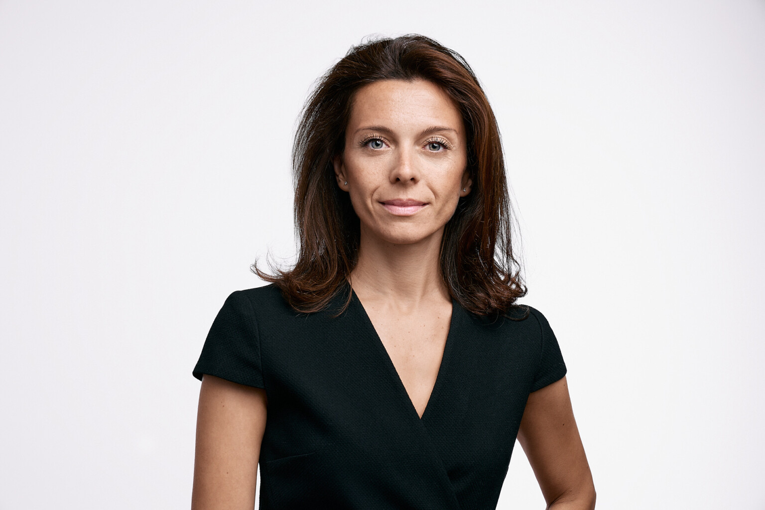 Frau mit schulterlangem Haar im schwarzen Top vor weißem Hintergrund, Business Headshot Frankfurt