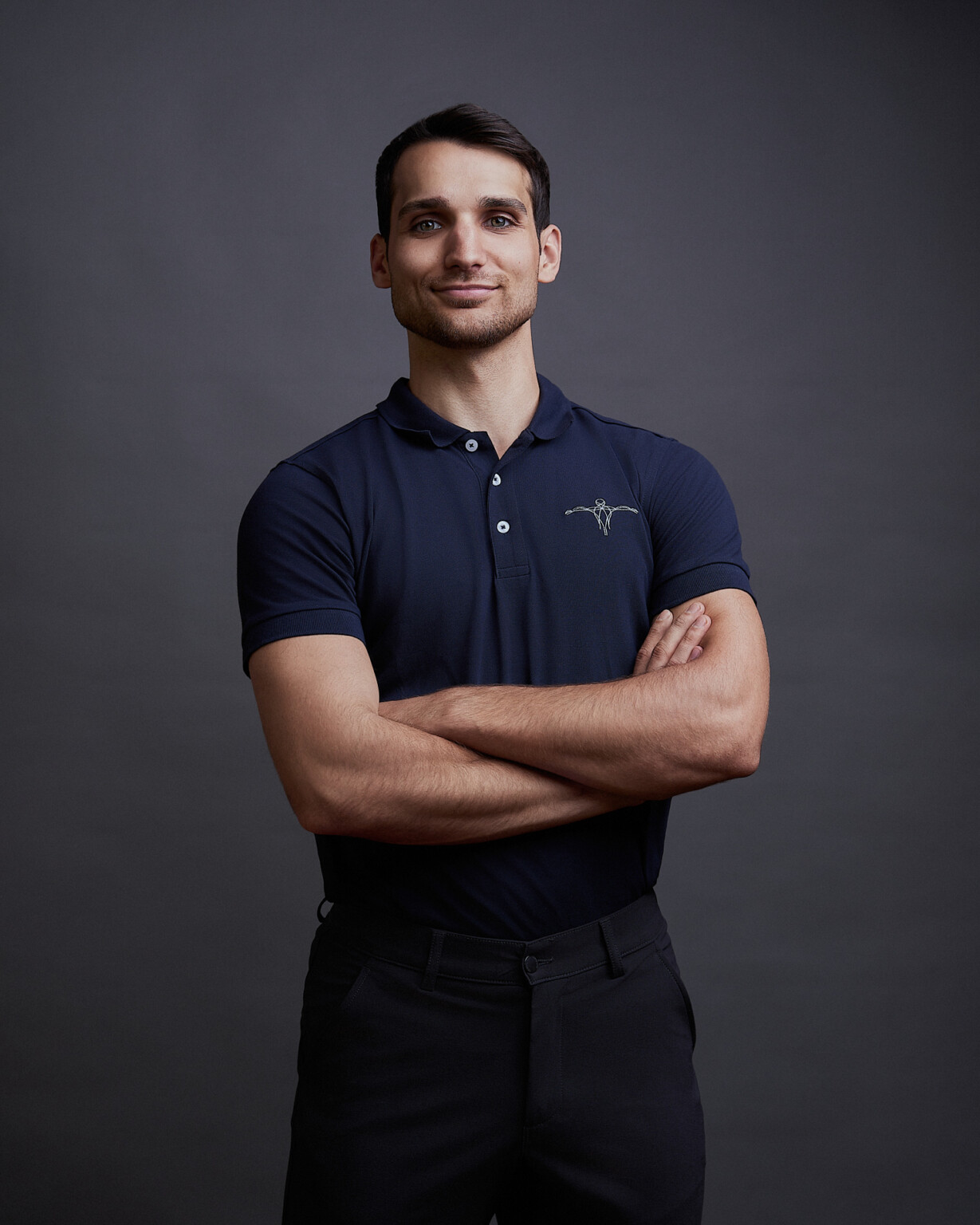 Mann in dunkelblauem Poloshirt mit verschränkten Armen, Business Casual Portrait Frankfurt