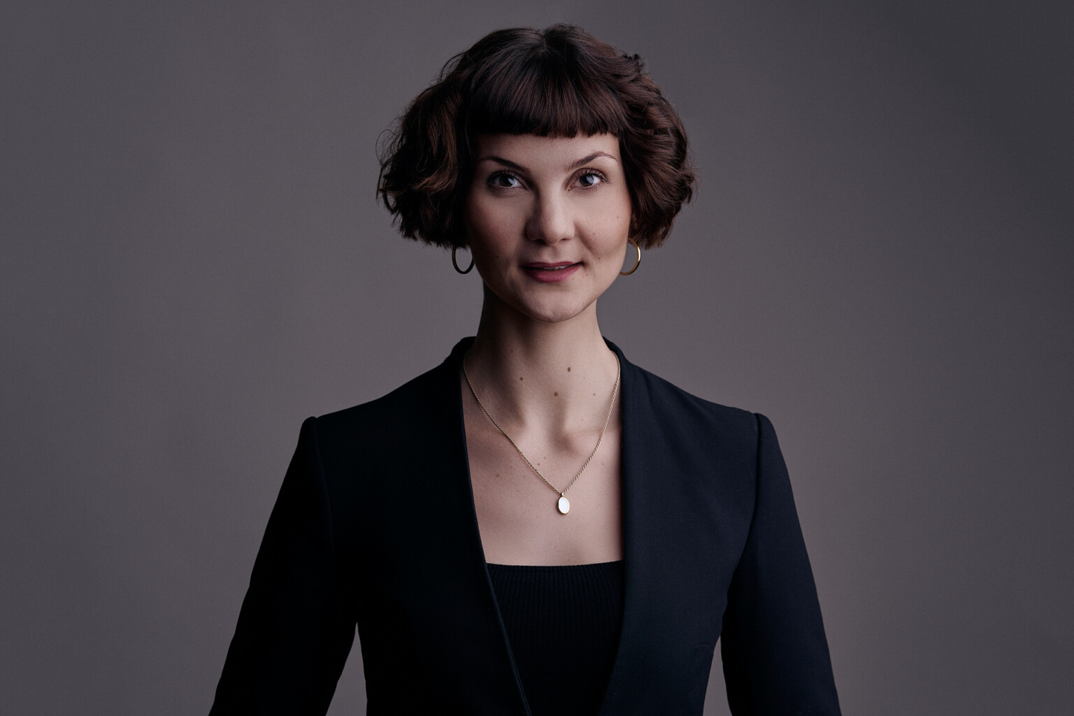 Frau mit lockigen kurzen Haaren im schwarzen Blazer, Business Headshot Frau Frankfurt