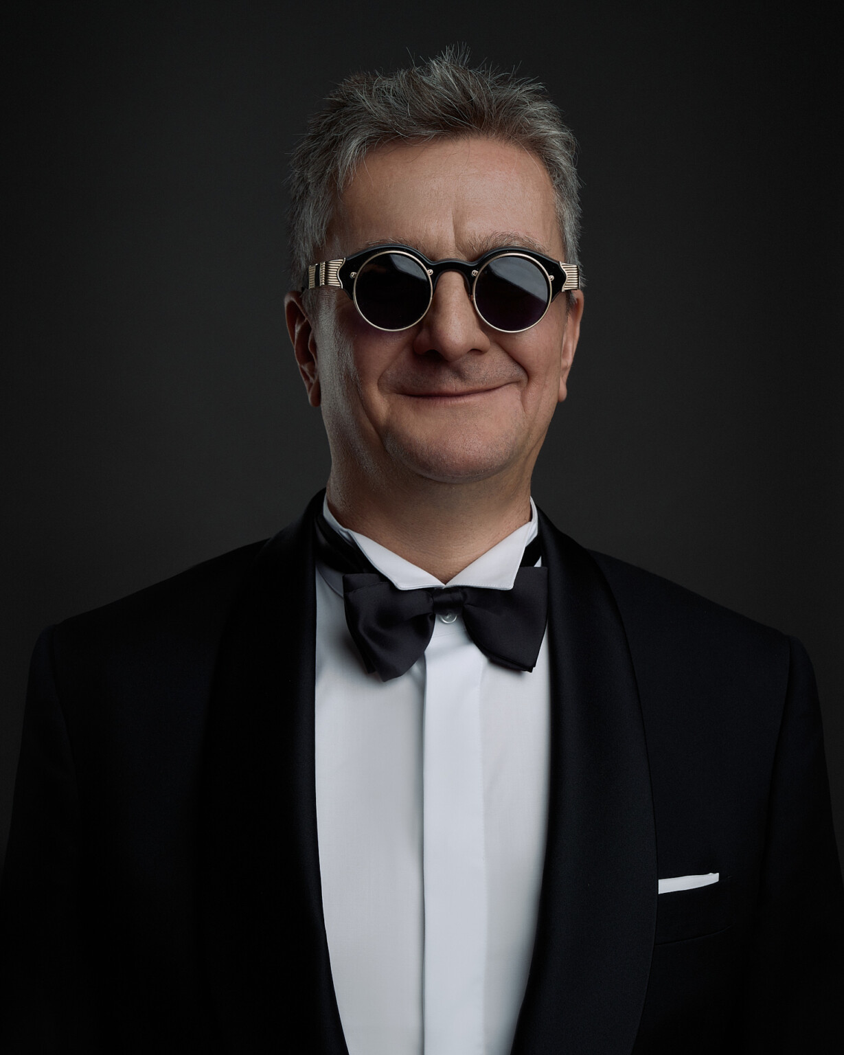 Lächelnder Mann mit grauem Haar im Smoking mit Sonnenbrille, Portrait Arthouse Studio Frankfurt