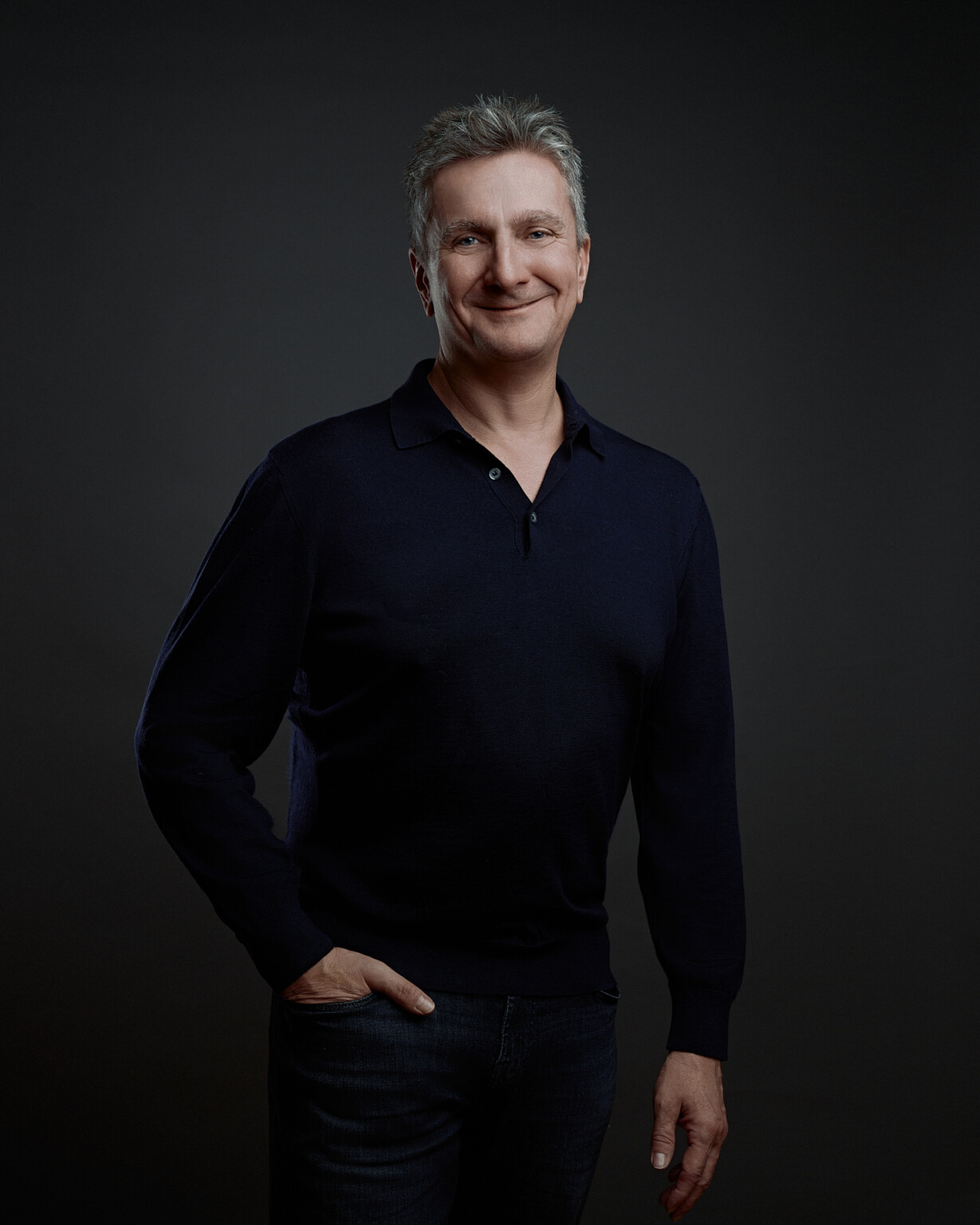 Geschäftsführer im dunklen Pullover vor dunklem Hintergrund, Corporate Portrait Frankfurt