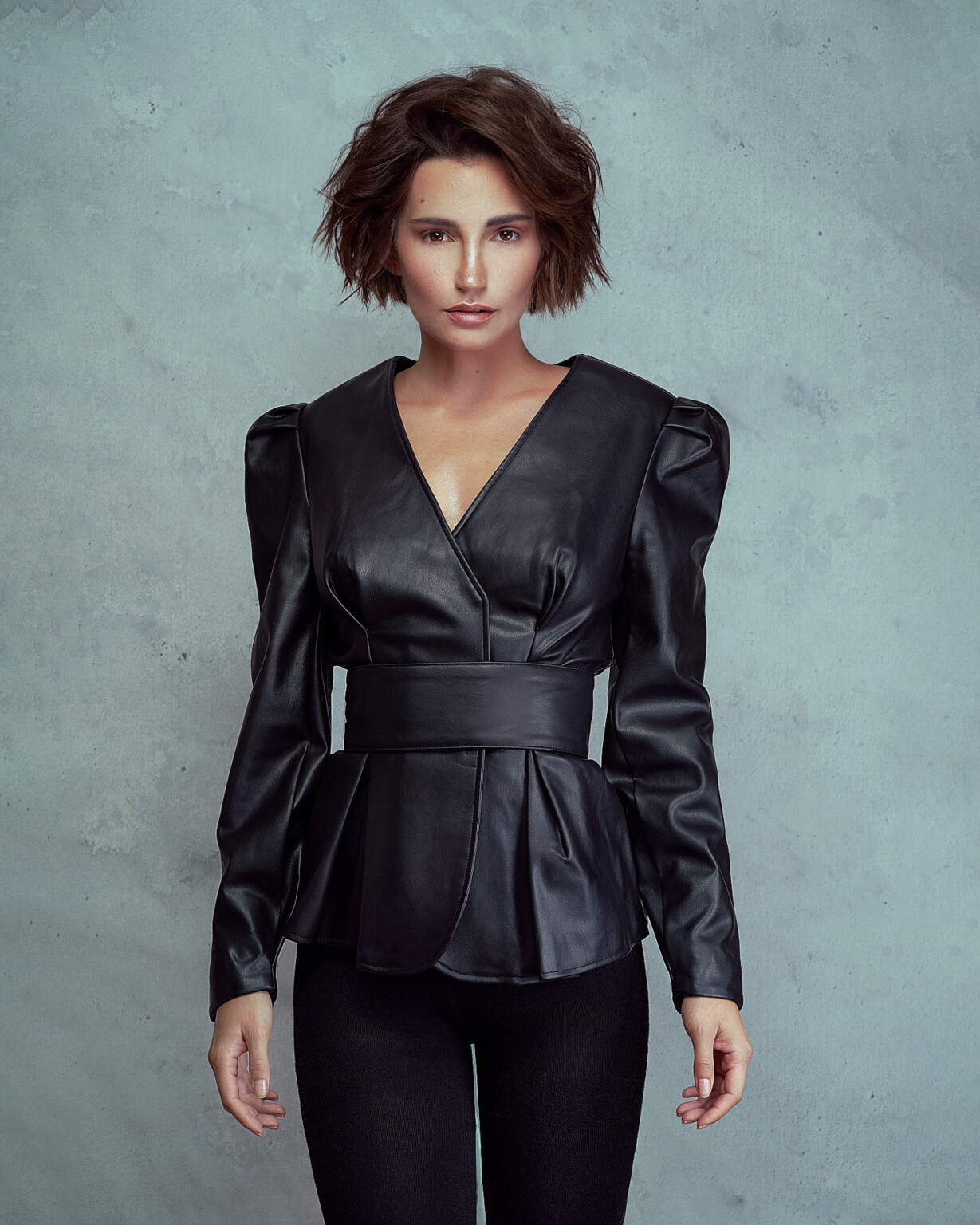 Janina Schiedlofsky in schwarzer Lederjacke mit Puffärmeln vor hellem Beton, Model Shooting Frankfurt