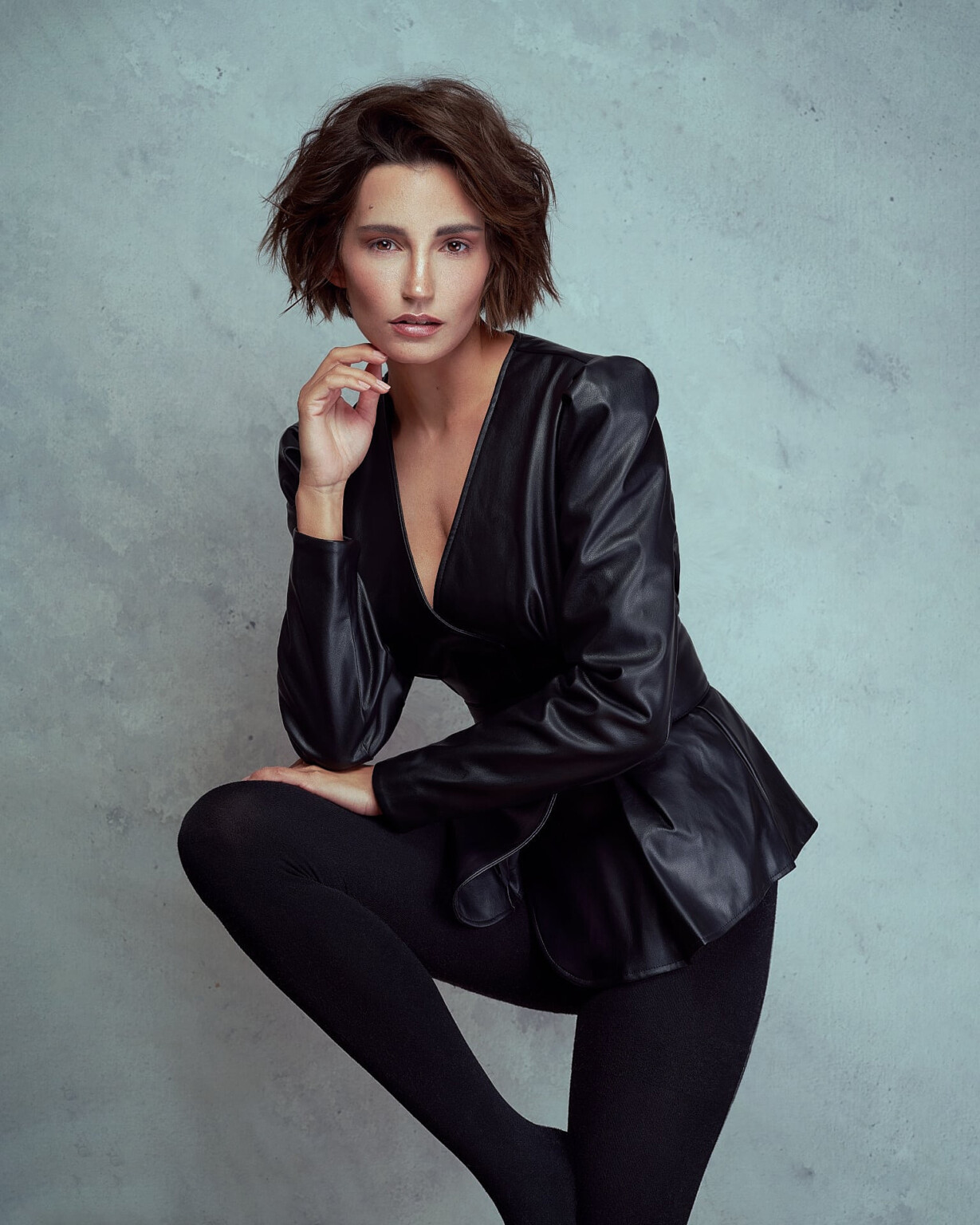 Model Shooting: Janina Schiedlofsky in Lederjacke mit angewinkeltem Bein vor Beton