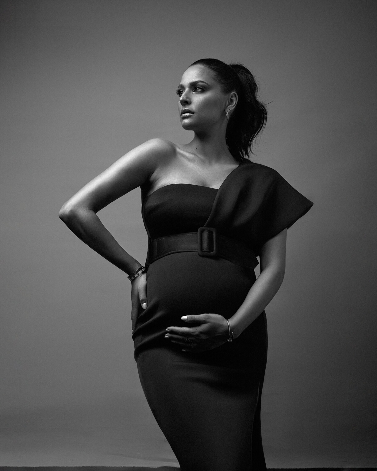 Amira Aly in Schwarzweiß im One-Shoulder-Kleid mit Gürtel, Babybauch-Shooting