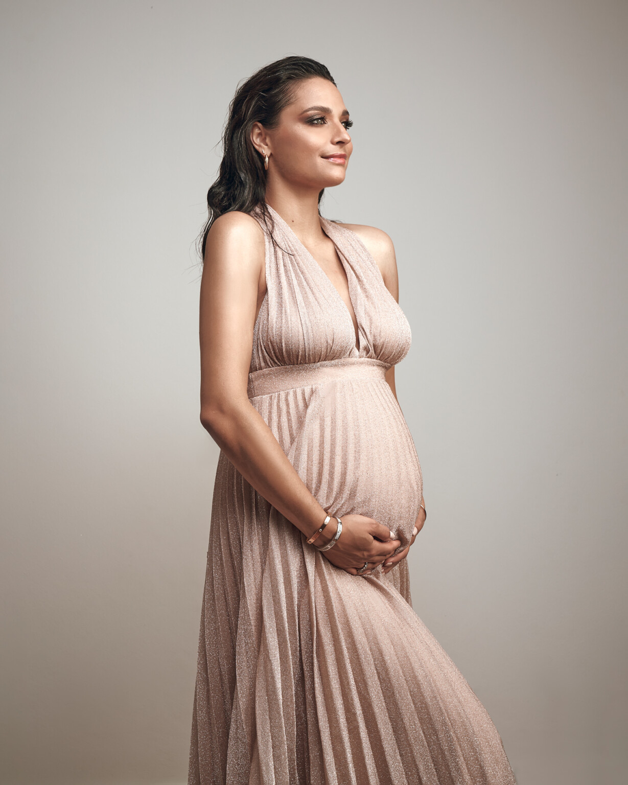 Amira Aly im Profil im Kleid in Rosé, Babybauch-Shooting