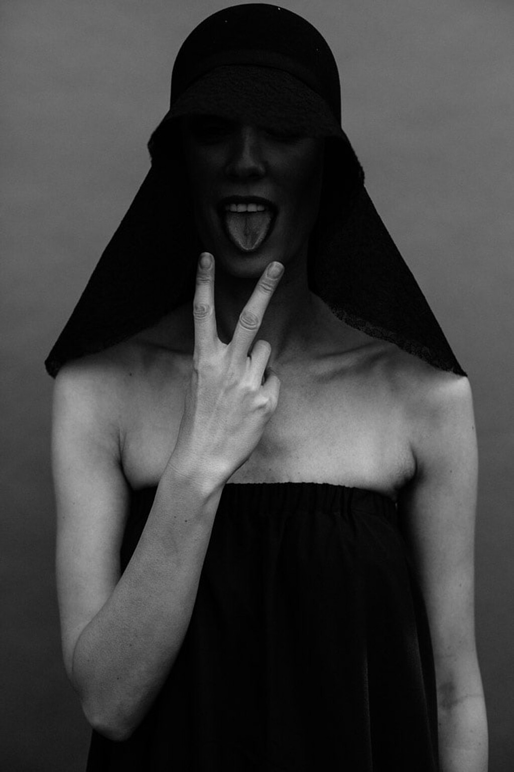 Boudoir Frankfurt 28 Schwarzweiß Portrait Frau mit Kopfbedeckung und Peace-Zeichen, verspieltes Editorial Portrait