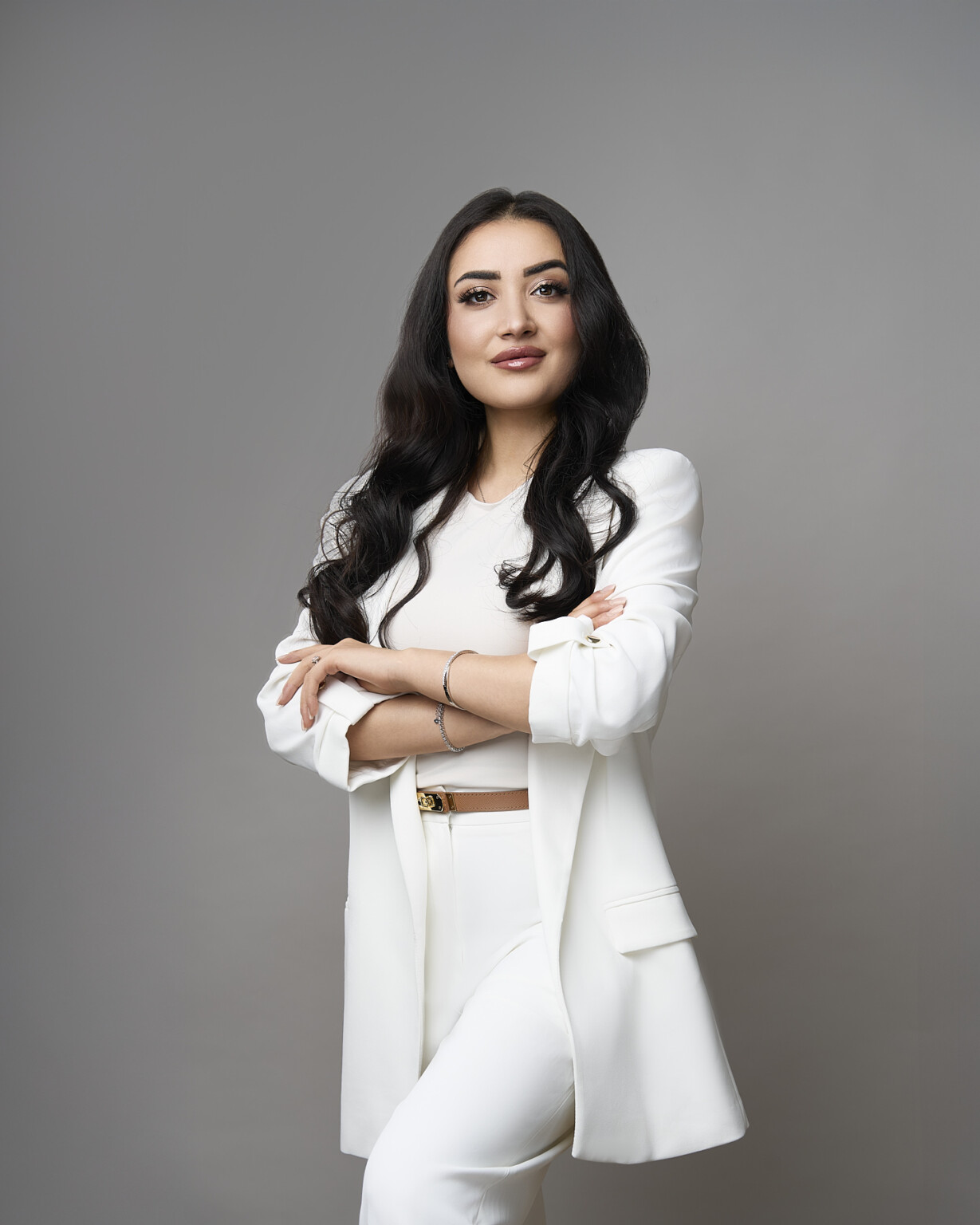 Frau im weißen Anzug mit verschränkten Armen vor grauem Hintergrund, Business Portrait Frau Frankfurt