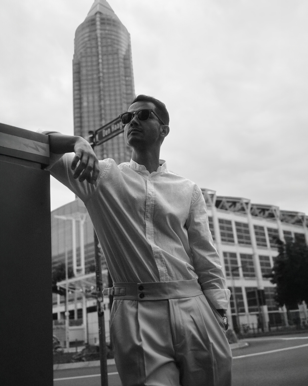 Mann mit Sonnenbrille lehnt an einem Gebäude in der Stadt, Business Casual Outdoor Portrait Frankfurt