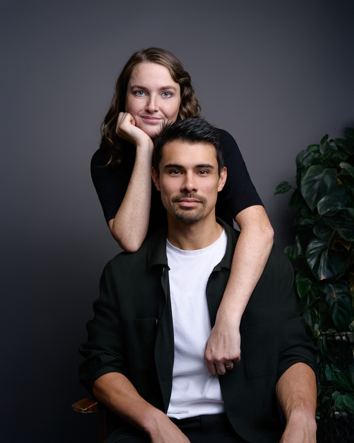 Business Casual Portraits: Frau legt die Arme auf die Schultern des sitzenden Mannes, Fotostudio Frankfurt