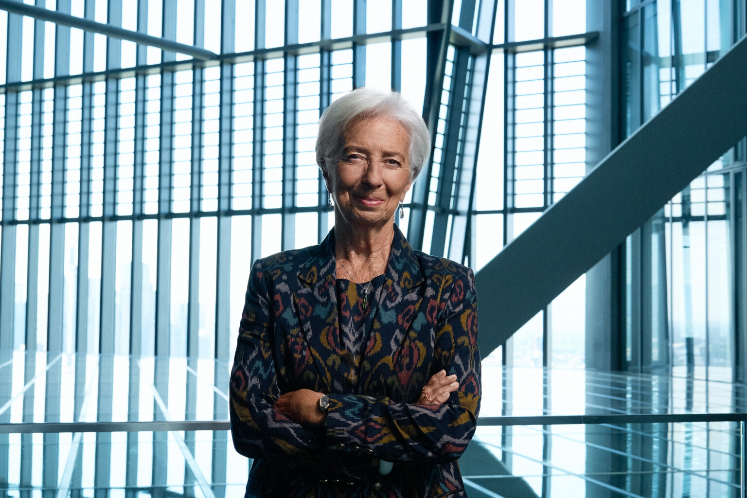 Christine Lagarde mit verschränkten Armen vor der Glasfassade der EZB, Business Portrait Frankfurt