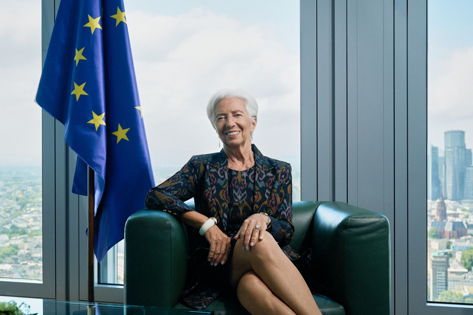 Business Headshots 1 Christine Lagarde smiling in a green armchair next to the EU flag, business portrait at the ECB in Frankfurt by Sebastian Schueler