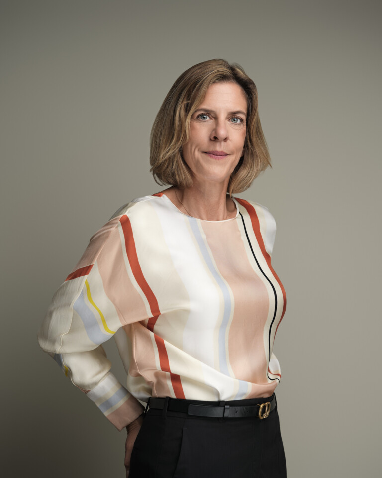 Frau mit blondem Bob in gestreifter Seidenbluse vor grauem Hintergrund, Business Portrait Frankfurt